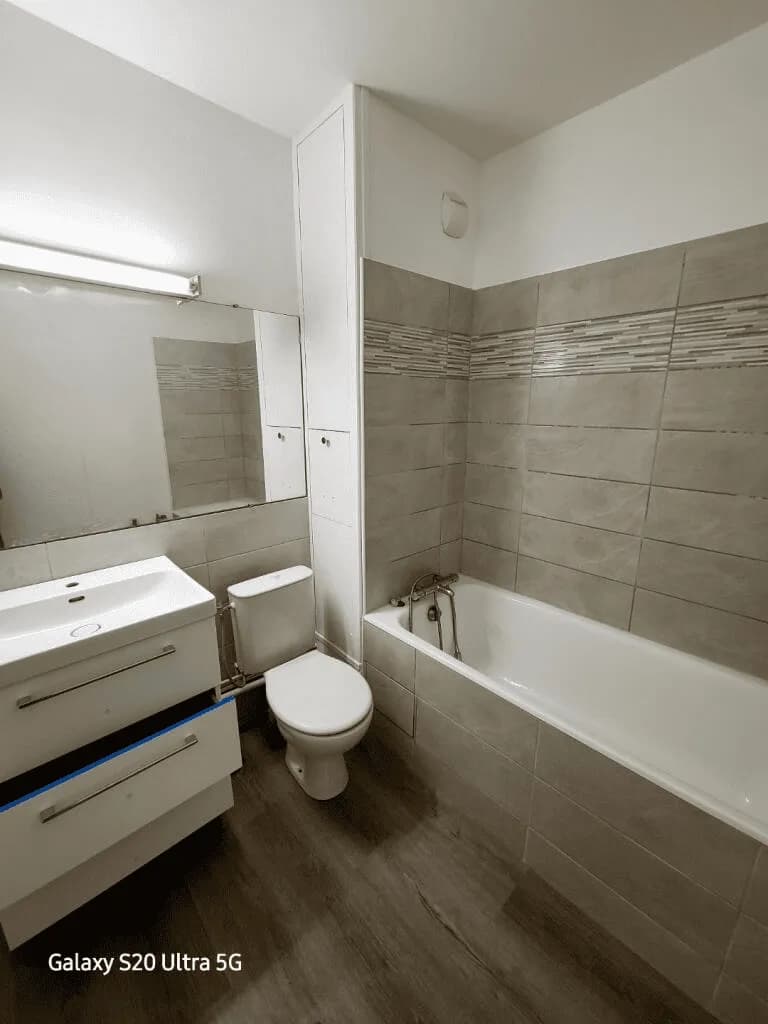 Salle de bains rénovée avec faïence et baignoire
